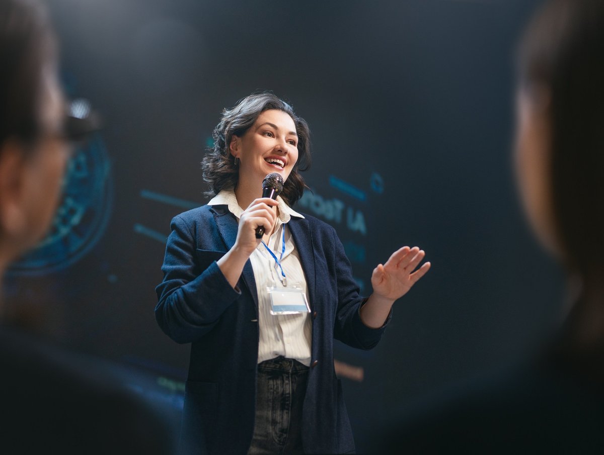Inspired professional woman delivers a dynamic speech at a business seminar, radiating confidence and engagement